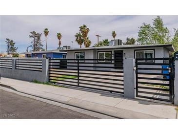 Charming home featuring a modern metal gate, gray exterior paint and beautiful desert landscaping with a blue sky backdrop at 244 N 19Th St, Las Vegas, NV 89101