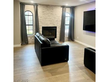 Contemporary living room boasts stone fireplace, hardwood floors, and plenty of natural light at 4083 Nook Way # A, Las Vegas, NV 89103