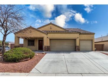 Inviting single-story home featuring a two-car garage and desert landscaping at 6636 Brent Scott St, North Las Vegas, NV 89086