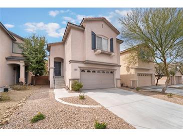 Two-story home with attached two car garage and low maintenance desert landscaping in front at 7013 Pacific Coast St, Las Vegas, NV 89148