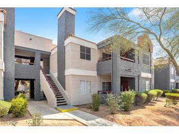 Well maintained condo exterior with stairs leading to the second floor and mature landscaping at 8600 W Charleston Blvd # 2078, Las Vegas, NV 89117