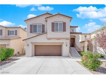 Inviting two-story home featuring neutral tones, shutters, desert landscaping, and an attached two-car garage at 10973 Sardinia Sands Dr, Las Vegas, NV 89141