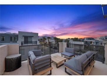 Enjoy the open air on this cozy rooftop patio with modern furniture and views of the surrounding community at 11325 Gravitation Dr, Las Vegas, NV 89135