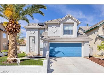 Charming two-story home features a vibrant blue garage door and mature landscaping with a tall palm tree at 3329 Buffalo Narrows Cir, Las Vegas, NV 89129