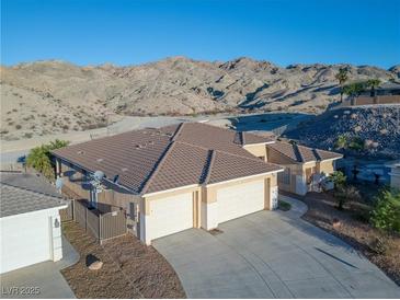 Stunning exterior view with a three-car garage and a mountain backdrop at 3439 Cottage Canyon St, Laughlin, NV 89029