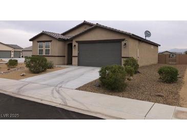 Charming single-story home featuring desert landscaping, a two-car garage, and a concrete driveway at 3530 E Moffat Ave, Pahrump, NV 89061