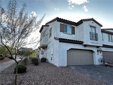 Charming stucco townhome featuring a two-car garage and desert landscaping at 727 Pickled Pepper Pl, Henderson, NV 89011