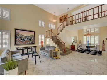 Bright living room with marble floors, a staircase, and modern decor creates an inviting space at 7613 Hackensack Ct, Las Vegas, NV 89128