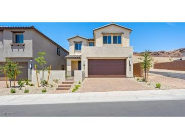 Inviting two-story home with a paver driveway, desert landscaping, and a neutral color scheme at 74 Via Montoro, Henderson, NV 89011
