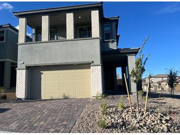 Two-story home with a two-car garage, porch, and balcony on a sunny day at 12434 Parkscene Pl, Las Vegas, NV 89138