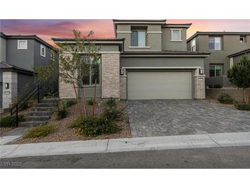 Beautiful two-story home featuring stone accents and a spacious two-car garage and a beautiful brick driveway at 12457 Sunset Sage Ave, Las Vegas, NV 89138