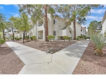 Inviting condo exterior with mature trees, meticulous landscaping, and walkways at 7901 Idledale Ct # 102, Las Vegas, NV 89145
