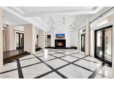 Bright living room features a fireplace, high ceilings, and designer tile flooring at 9 Greely Club Trl, Henderson, NV 89052