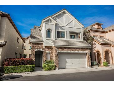 Charming two-story home featuring stone accents, a two-car garage, and manicured landscaping at 9173 Whitekirk Pl, Las Vegas, NV 89145