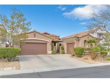Charming single-story home featuring a three-car garage, terra cotta roof, and desert landscaping at 10024 Scenic Walk Ave, Las Vegas, NV 89149