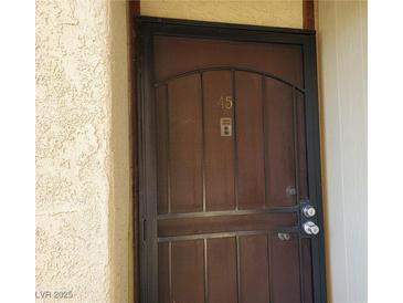 Metal security screen door with door number 45 and doorbell on a light beige stucco building at 3168 S Eastern Ave # 45, Las Vegas, NV 89169