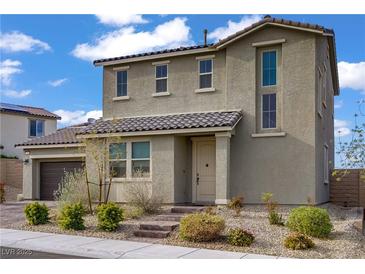 Two-story home boasts a tiled roof, landscaped front yard, and attached two car garage at 10290 Lodge Pine Ave, Las Vegas, NV 89166