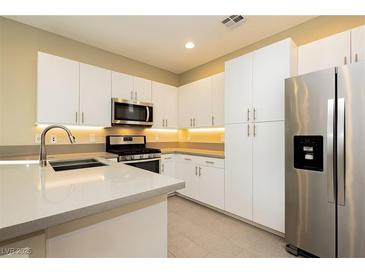 Bright kitchen features modern white cabinetry, stainless steel appliances, and sleek countertops at 11236 Rainbow Peak Ave # 210, Las Vegas, NV 89135