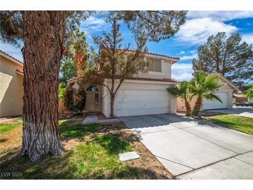 Inviting two-story home featuring a well-maintained lawn, mature trees, and a two-car garage at 2819 Prickley Pear Dr, Henderson, NV 89074