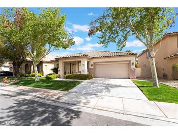 Charming single-story home featuring a two-car garage, desert landscaping, and covered front porch at 3057 Sunrise Heights Dr, Henderson, NV 89052