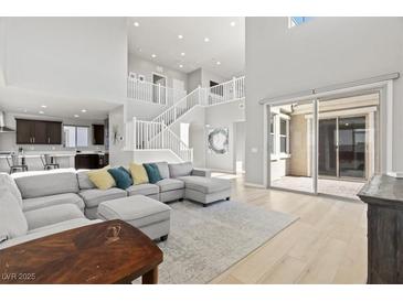 Bright, open living room with high ceilings, modern decor, and sliding glass doors to outdoor space at 3062 Echoed Rondel Ln, Henderson, NV 89044
