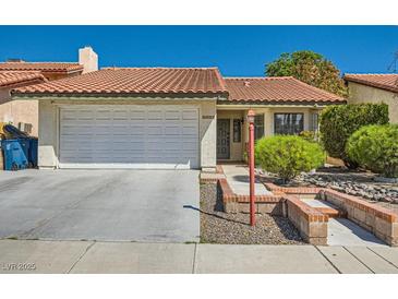 Charming home featuring a tile roof, two-car garage, manicured landscaping, and a brick-lined walkway to the front door at 3314 Astoria Dr, Las Vegas, NV 89121