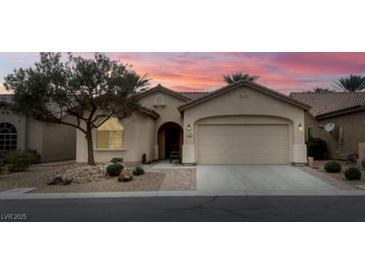 Inviting single-story home featuring a two-car garage, desert landscaping, and a covered entry way, perfect for easy living at 3335 American Mustang Ct, Las Vegas, NV 89122