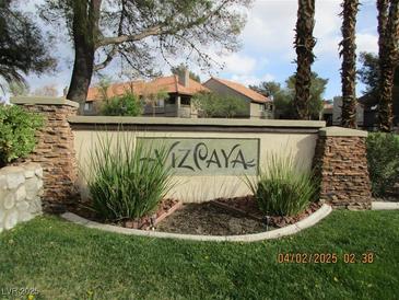 Community entrance sign featuring stone pillars and lush landscaping at 5038 S Rainbow Blvd # 206, Las Vegas, NV 89118