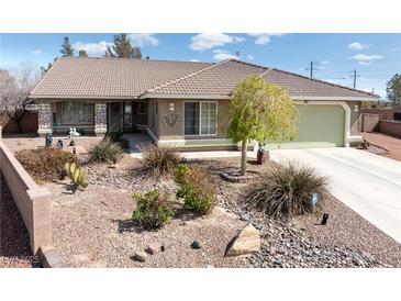 Landscaped front yard featuring desert landscaping, a light brown exterior, and a tile roof under a bright, blue sky at 5481 Lincolnwood Ct, Pahrump, NV 89061