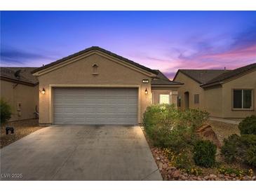 Charming single-story home with well-maintained landscaping and a two-car garage under a colorful sunset at 7849 Lily Trotter St, North Las Vegas, NV 89084