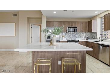 Modern kitchen boasts a large island, stainless appliances, and stylish backsplash at 8255 Las Vegas Blvd # 802, Las Vegas, NV 89123