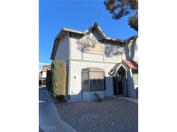 Charming two-story townhouse featuring neutral stucco and landscaped gravel, creating a welcoming curb appeal at 890 Ripple Way, Las Vegas, NV 89110