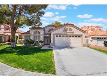 Charming single-story home with a well-manicured lawn, mature trees, and a two-car garage in a sunny neighborhood at 289 Garwood Ct, Henderson, NV 89074