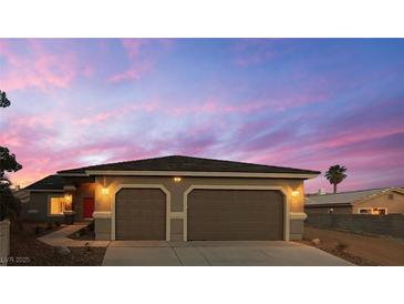 Charming single-story home featuring a two-car garage and desert landscaping at 1931 Rose Ct, Pahrump, NV 89048
