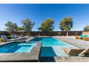 Sparkling pool and spa surrounded by lounge chairs and desert landscaping at 8637 Home Gate Ct, Las Vegas, NV 89113