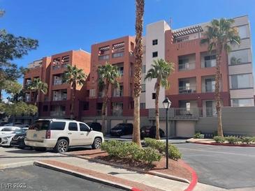 Condominium complex with well-maintained landscaping and palm trees on a clear, sunny day at 15 E Agate Ave # 202, Las Vegas, NV 89123