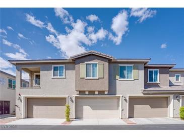 Modern townhouse exterior with three garage doors and neutral color palette under blue sky at 25 Barbara Ln # 57, Las Vegas, NV 89183