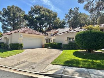 Charming single-story home with a well-maintained lawn, mature trees, and a spacious two-car garage at 6987 Emerald Springs Ln, Las Vegas, NV 89113