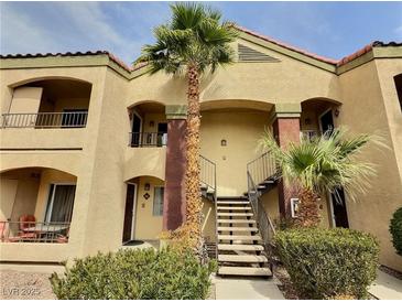 Inviting condo complex with charming architecture, palm trees, and access stairs at 7885 W Flamingo Rd # 2153, Las Vegas, NV 89147
