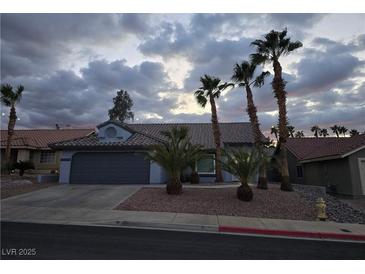 Charming single-story home featuring desert landscaping, mature palm trees, and a two-car garage at 853 Rusty Anchor Way, Henderson, NV 89002