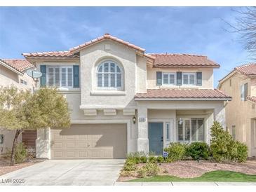 Charming two-story home featuring a tan stucco exterior, arched window, and a well-manicured front yard at 10004 W Cherokee Ave, Las Vegas, NV 89147