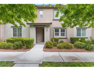 Charming two-story home with a landscaped yard featuring lush greenery and a welcoming entrance at 11408 Newton Commons Dr # 104, Las Vegas, NV 89135