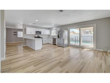 Bright open kitchen with white cabinets, stainless steel appliances, and views of the backyard pool at , Las Vegas, NV 89145