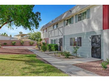 Charming townhome featuring a well-maintained lawn and quaint landscaping at 609 Greenbriar Townhouse Way, Las Vegas, NV 89121