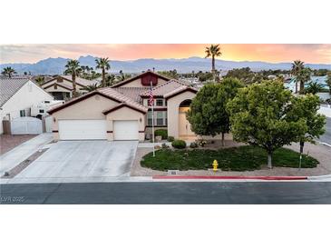 Charming single-story home featuring well-maintained landscaping, a three-car garage, and a beautiful sunset backdrop at 6493 Yellow Bells Ct, Las Vegas, NV 89131