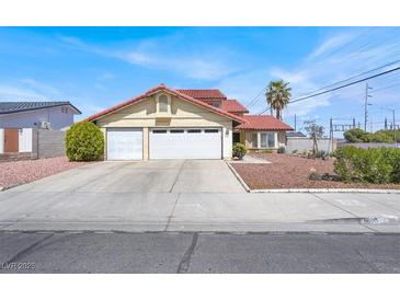 Inviting two-story home featuring a red tile roof and a spacious two-car garage at 8600 Soneto Ln, Las Vegas, NV 89117