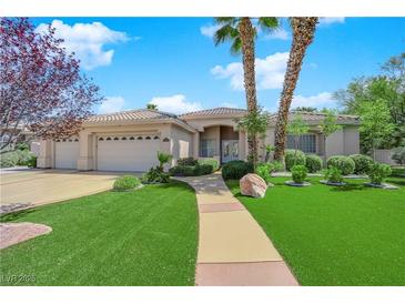 Inviting single-story home featuring desert landscaping, a three-car garage, and a tile roof at 4722 Blue Mesa Way, Las Vegas, NV 89129