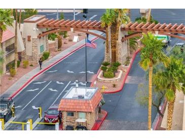 Guarded community entrance with mature landscaping and an American flag at 4421 Alexis Dr # 429, Las Vegas, NV 89103