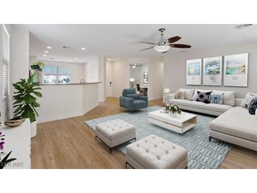 Bright living room with an open floor plan features wood floors, ceiling fan, modern furniture and decor at 1047 Amber Gate St, Henderson, NV 89002