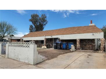 Modest single-story home with a brown-tiled roof and unique rock facade at 116 Continental Ave, Henderson, NV 89015
